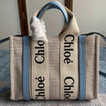 Small Strap Woody Tote Bag 26.5 in Beige Linen Canvas Black Webbing Logo Embroider Blue Calfskin