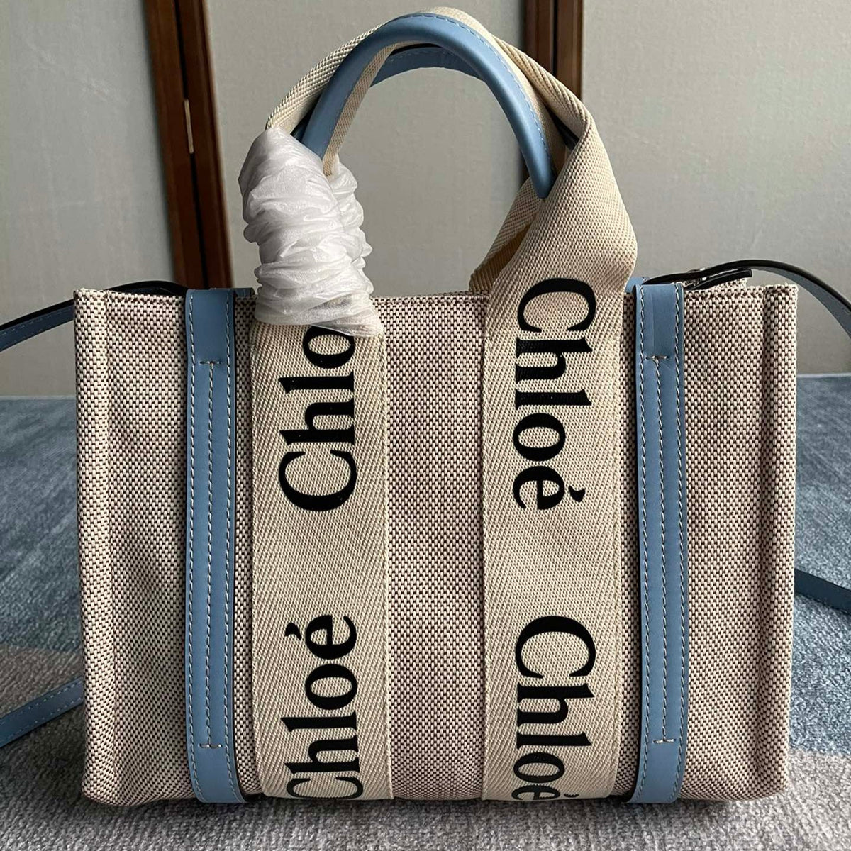Small Strap Woody Tote Bag 26.5 in Beige Linen Canvas Black Webbing Logo Embroider Blue Calfskin