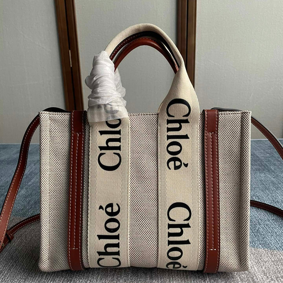 Small Strap Woody Tote Bag 26.5 in Beige Linen Canvas Black Webbing Logo Embroider Brown Calfskin